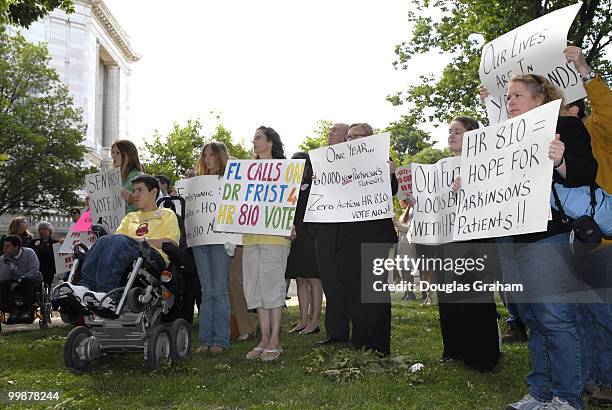 People hold up signs in the Upper Senate Park during a news conference to mark one-year anniversary of House passed stem cell research legislation...