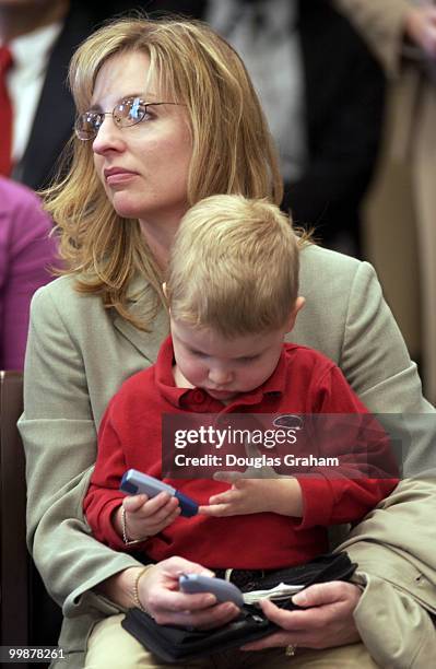 Zachary Hershey, age 3, seated on his mother Lori's lap checks his blood suger during news conference to urge President Bush to expand the federal...