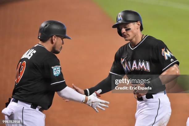 Miguel Rojas of the Miami Marlins congratulates Derek Dietrich after scoring a run in the first inning against the Philadelphia Phillies at Marlins...