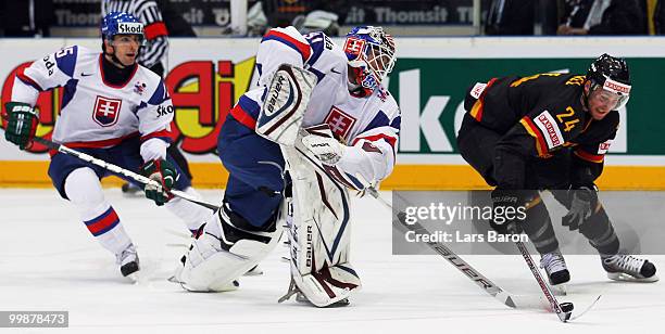 Goaltender Peter Budaj of Slovakia is challenged by Andre Rankel of Germany during the IIHF World Championship qualification round match between...