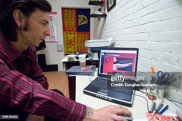 Paul Roe looks at his portfolio on-line at his tattoo / art studio called british Ink.