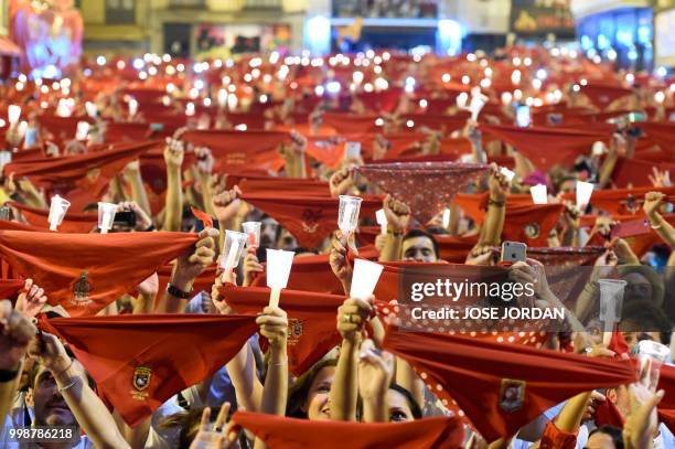 Revellers raise red scarves and candles as they sing the song 'Pobre de Mi', marking the end of the San Fermin festival in Pamplona, northern Spain...