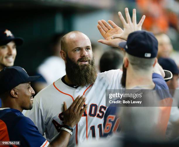 Evan Gattis of the Houston Astros receives high fives from the dugout after hitting a home run in the fifth inning against the Detroit Tigers at...