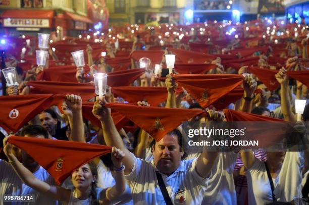 Revellers raise red scarves and candles as they sing the song 'Pobre de Mi', marking the end of the San Fermin festival in Pamplona, northern Spain...