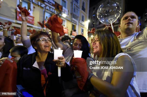 Revellers raise red scarves and candles as they sing the song 'Pobre de Mi', marking the end of the San Fermin festival in Pamplona, northern Spain...