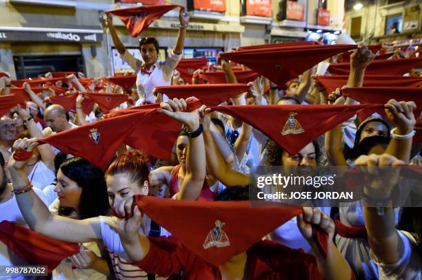 Revellers raise red scarves and candles as they sing the song 'Pobre de Mi', marking the end of the San Fermin festival in Pamplona, northern Spain...