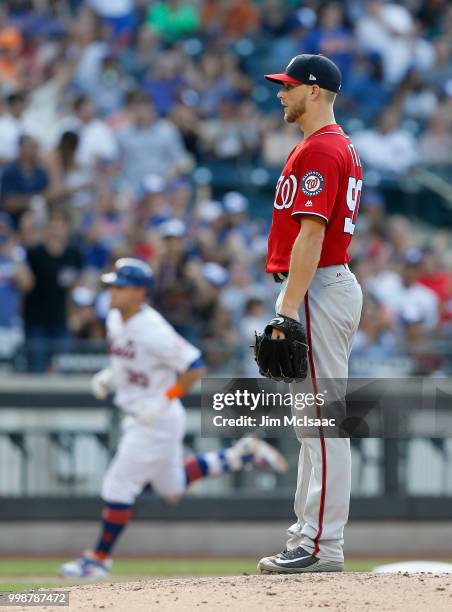 Austin Voth of the Washington Nationals looks on from the mound after surrendering a fifth inning three run home run against Michael Conforto of the...