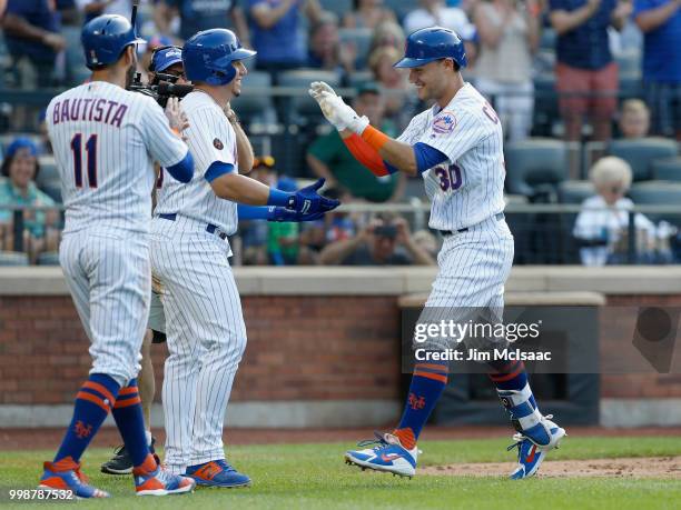 Michael Conforto of the New York Mets celebrates his fifth inning three run home run against the Washington Nationals with teammates Jose Bautista...