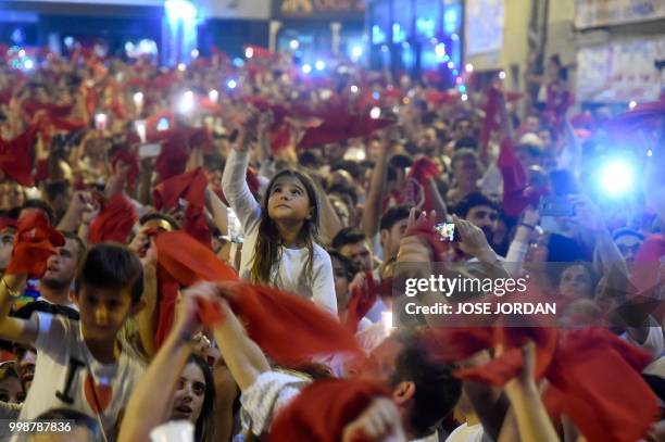 Revellers raise red scarves and candles as they sing the song 'Pobre de Mi', marking the end of the San Fermin festival in Pamplona, northern Spain...