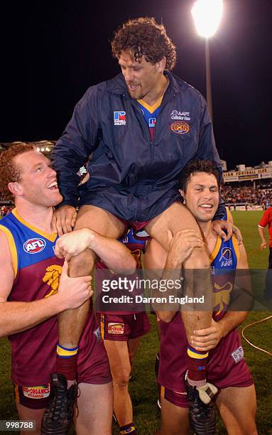 Darryl White is chaired off the ground by Justin Leppitsch and Chris Johnson of Brisbane after playing his 200th game against Richmond during the AFL...