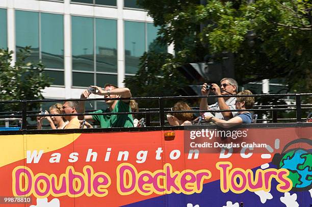 Tourist take pictures of the Upper Senate Park with the U. S. Capitol in the background from the top of a Washington, D.C. Double decker tour bus on...