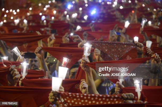 Revellers raise red scarves and candles as they sing the song 'Pobre de Mi', marking the end of the San Fermin festival in Pamplona, northern Spain...