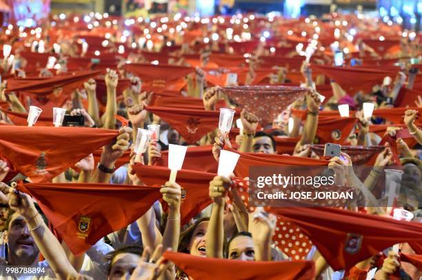 Revellers raise red scarves and candles as they sing the song 'Pobre de Mi', marking the end of the San Fermin festival in Pamplona, northern Spain...