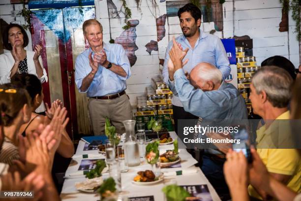 Senator Bill Nelson, a Democrat from Florida, center, and Senator Catherine Cortez Masto, a Democrat from Nevada, left, applaud during a Vecinos de...