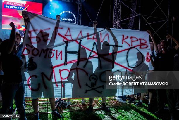 Activists hold anti-nato transparent and protest against NATO during a Macedonian's celebration for invitation to join NATO at an event in Skopje On...