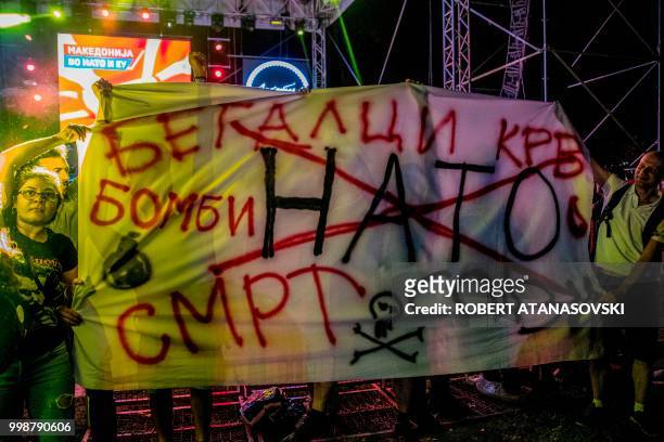 Activists hold anti-nato transparent and protest against NATO during a Macedonian's celebration for invitation to join NATO at an event in Skopje On...