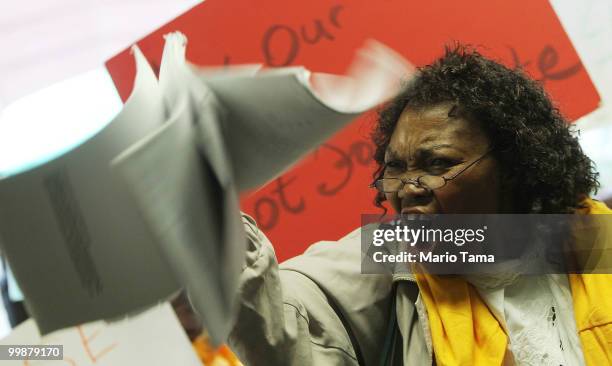 Carmen Edwards waves her mortgage papers during a demonstration outside JPMorgan Chase's annual shareholder meeting in downtown Manhattan May 18,...