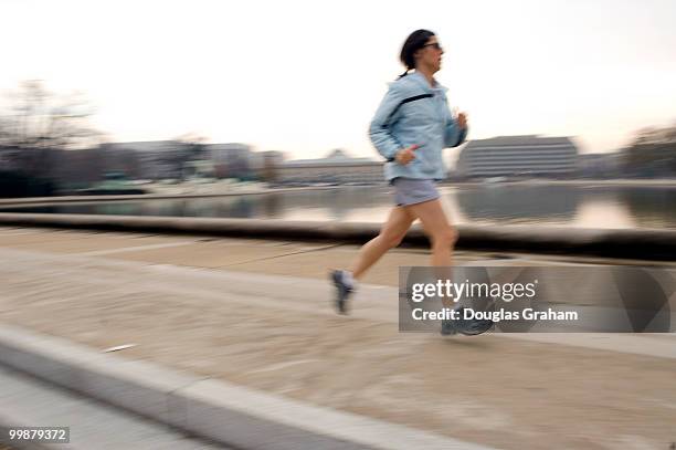 Lunch time runner enjoys the spring like weather on the West Front of the U.S. Capitol along the reflecting pool, December 10, 2007.