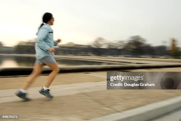 Lunch time runner enjoys the spring like weather on the West Front of the U.S. Capitol along the reflecting pool, December 10, 2007.