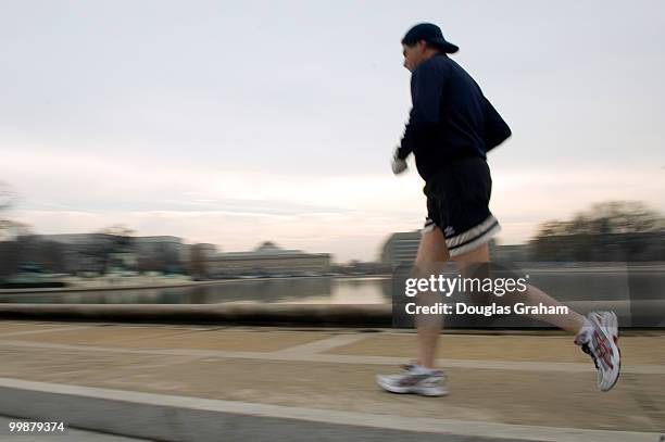 Lunch time runner enjoys the spring like weather on the West Front of the U.S. Capitol along the reflecting pool, December 10, 2007.