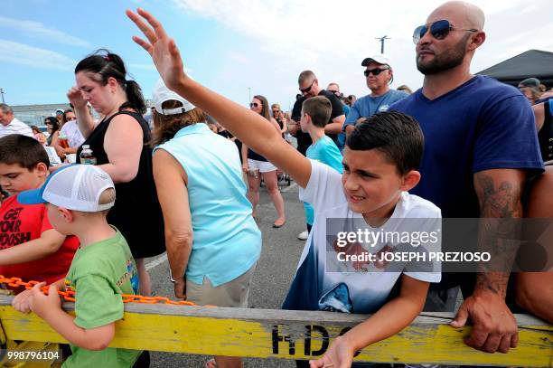 Landon Cabral raises his hand to answer questions about sharks and hopes to win a prize while waiting for a shark to be brought ashore at the 32nd...