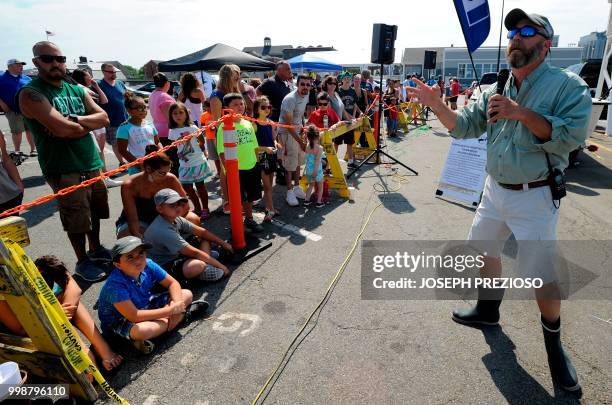 Dr. Matt Philips, a neurosurgeon, entertains a crowed of over 100 children and parents with shark facts while waiting for sharks to come ashore to be...