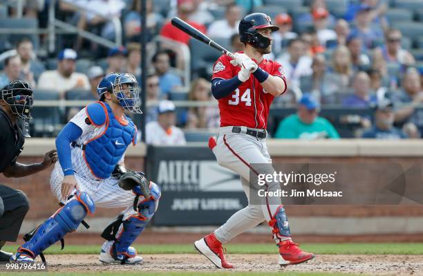Bryce Harper of the Washington Nationals follows through on a sixth inning RBI single against the New York Mets at Citi Field on July 14, 2018 in the...