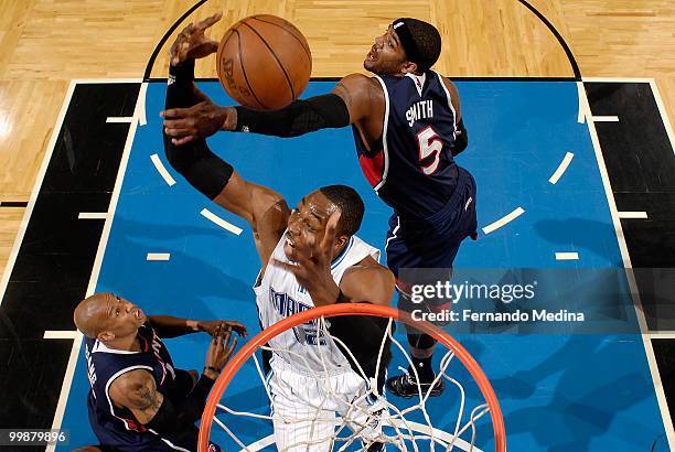 Dwight Howard of the Orlando Magic tries to hold on to the ball under pressure from Josh Smith and Maurice Evans of the Atlanta Hawks in Game One of...