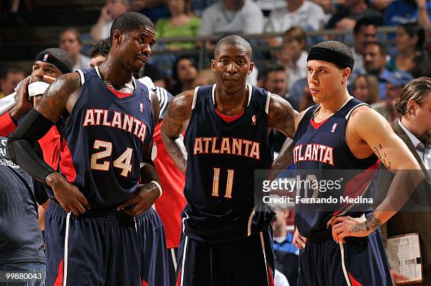 Marvin Williams, Jamal Crawford and Mike Bibby of the Atlanta Hawks stand on the court during a break against the Orlando Magic in Game One of the...