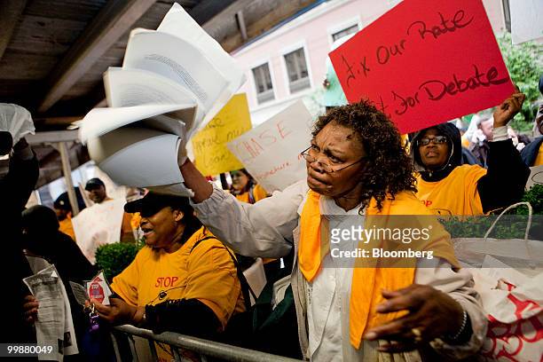 Carmen Edwards holds a copy of her mortgage, which she claimed Chase bank had put into foreclosure despite her making payments, at a demonstration...