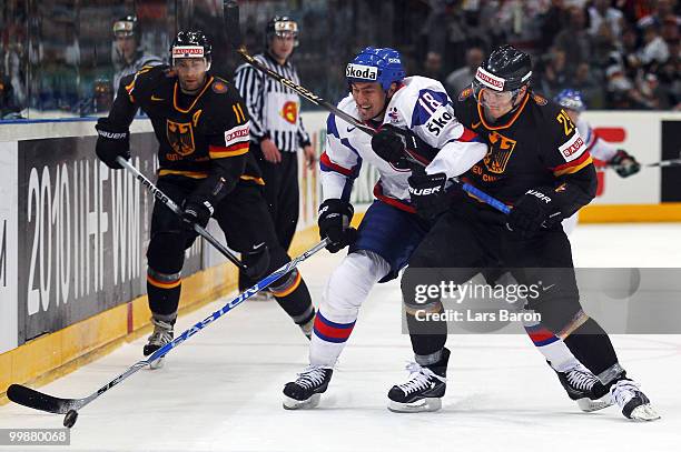 Miroslav Satan of Slovakia is blocked by Alexander Barta of Germany during the IIHF World Championship qualification round match between Slovakia and...