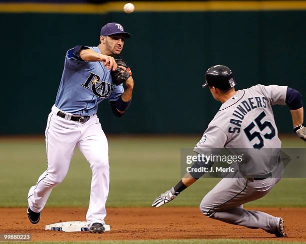 Infielder Sean Rodriguez of the Tampa Bay Rays throws over base runner Michael Saunders of the Seattle Mariners to complete a double play during the...