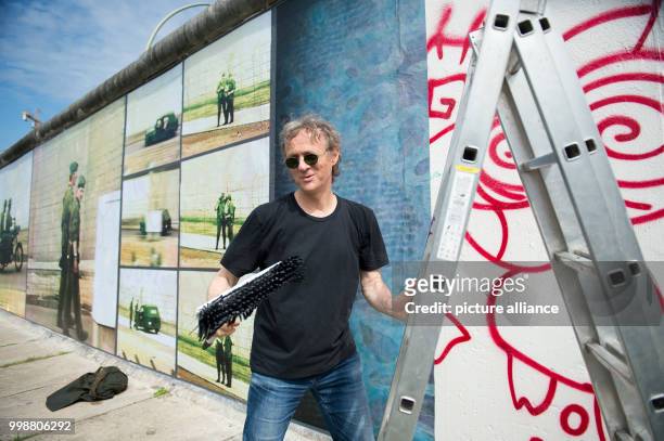 Artist Stefan Roloff standing at the back side of the East Side Gallery during his open-air installation "Beyond the Wall" in Berlin, Germany, 10...