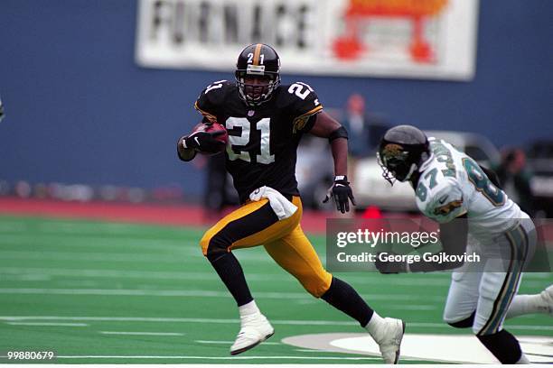 Defensive back Deon Figures of the Pittsburgh Steelers runs with the football after intercepting a pass against wide receiver Keenan McCardell of the...
