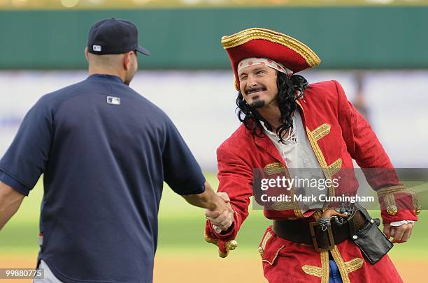 Captain Morgan and Alex Avila of the Detroit Tigers shake hands during pre-game ceremonies before the baseball game between the Detroit Tigers and...