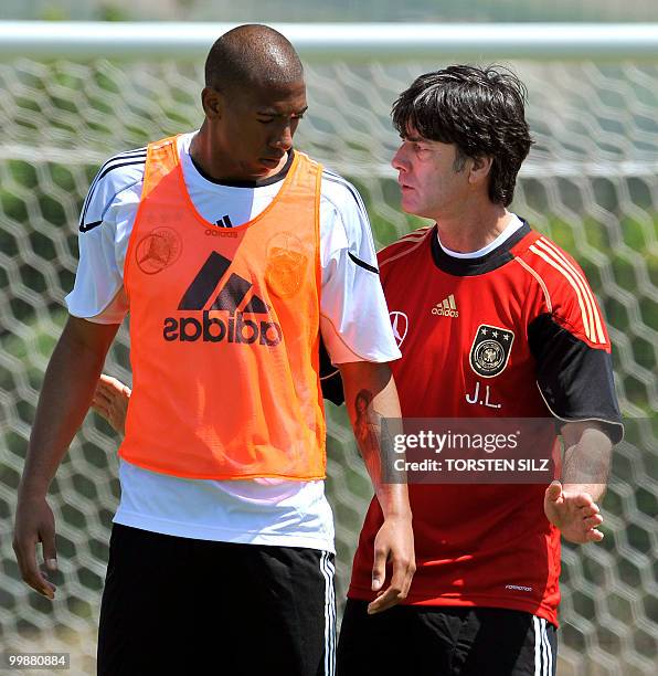 Germany's coach Joachim Loew gives instructions to Germany's defender Jerome Boateng during a training session at the Verdura Golf and Spa resort,...