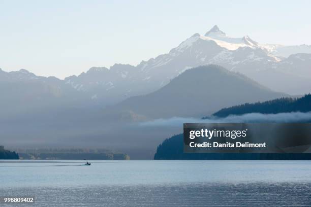 fishing boat on baker lake heading toward mt. shuksan, washington state, usa - mt baker stockfoto's en -beelden