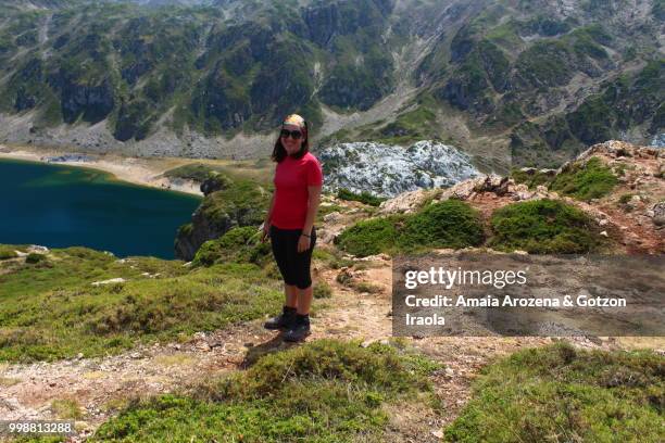 a woman hiker on calabazosa lake. somiedo natural park, asturias, spain. - ökologisches reservat stock-fotos und bilder