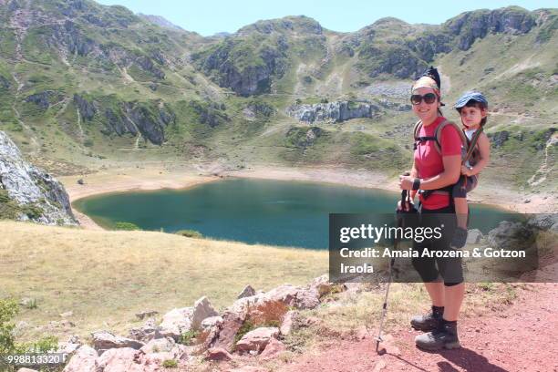 mother and daughter on cueva lake. somiedo natural park, asturias, spain. - cueva stockfoto's en -beelden