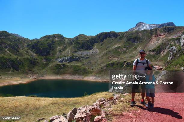 father and son on cueva lake. somiedo natural park, asturias, spain. - cueva stockfoto's en -beelden