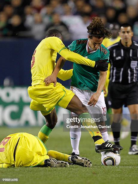 Andres Guardado of Mexico is held by Alpha Ba of Senegal after B.Y. Karamba Diallo fell injured during an international friendly at Soldier Field on...