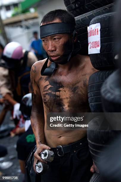 An anti-government red shirt protester holds home made explosives as he stands behind a barricade on May 18, 2010 in Bangkok, Thailand. Protesters...