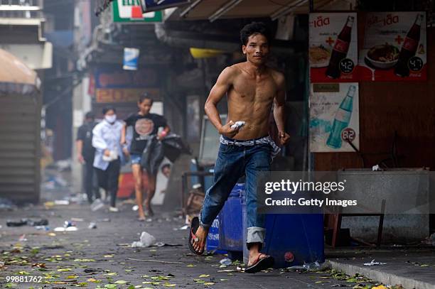 Thais run down the sidewalk of a street near a major flash point on May 18, 2010 in Bangkok, Thailand. Protesters have clashed with military forces...