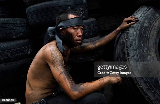 An anti-government red shirt protester rests behind a barricade on May 18, 2010 in Bangkok, Thailand. Protesters have clashed with military forces...