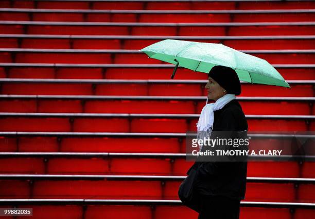 Tourist waits in the rain outside the Broadway Ticket office in Times Square in New York May 18, 2010. AFP PHOTO /TIMOTHY A. CLARY