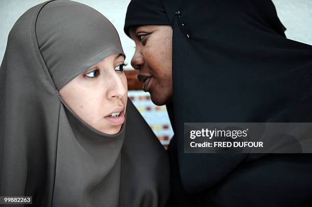 Muslim women wearing headdresses talk during a meeting with Imam Ali El Moujahed to give a testimony on their daily life on May 18, 2010 in...