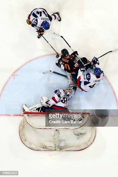 Patrick Hager of Germany is challenged by Andrej Sekera, Richard Lintner and goaltender Peter Budaj of Slovakia during the IIHF World Championship...