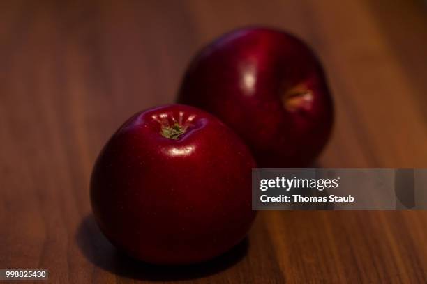 red apples on a wooden table - staub stock pictures, royalty-free photos & images