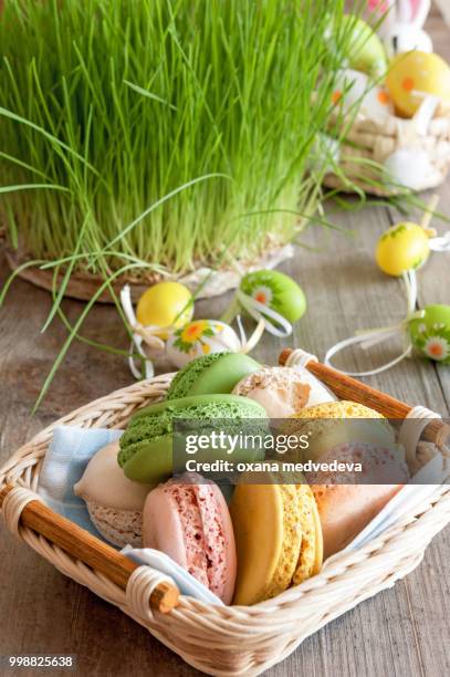 multicolored meringues macaroons in a wicker basket easter eggs - eggs in basket stock pictures, royalty-free photos & images