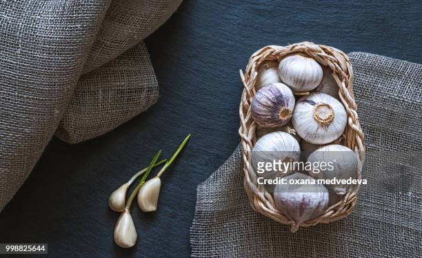 garlic in a wicker basket on a rustic - medvedeva ストックフォトと画像